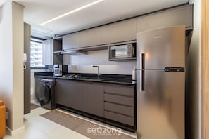 Una cocina moderna con electrodomésticos de acero inoxidable, microondas empotrado y lavavajillas.