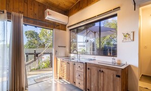 Uma cozinha moderna com armários de madeira, uma janela grande e vista para o exterior.