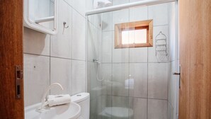 A bathroom with a sink, toilet, and glass-enclosed shower. - Cozy Cabin 10 min From Praia do Rosa Prj025 (Imbituba)