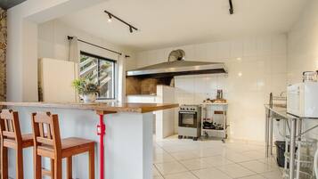 A modern kitchen with a central island, a stove, and a microwave.