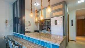 Una cucina moderna con piani in granito, lavello incassato e frigorifero.