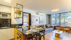 Una cocina moderna con microondas, estufa y comedor con mesa lista para dos.
