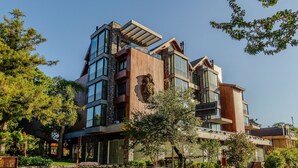 Un edificio de varios pisos con amplios ventanales y fachada de piedra y madera.