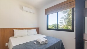 Quarto de hotel com uma cama, janela e ar condicionado.