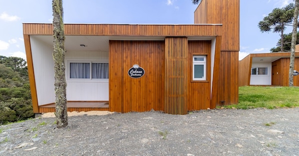 Una cabana de fusta moderna amb un rètol que diu "Cabana Caboeca".