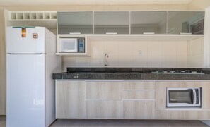 Eine moderne Küche mit Einbau-Mikrowelle, Kühlschrank und Herd.
