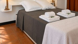 A hotel room with a bed, two bedside lamps, a window with curtains, and a tiled floor. - Cozy Studio 150 meters from the beach (Les Trois-Îlets)