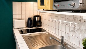 A kitchen with a stainless steel sink, a microwave, a toaster, and a coffee maker. - Cozy Studio 150 meters from the beach (Les Trois-Îlets)