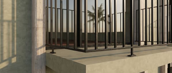 A modern balcony with a metal railing and a concrete ledge.