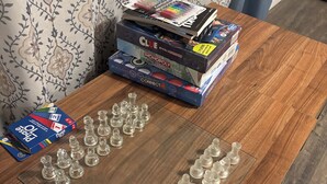 A wooden table with board games and game pieces. - Perfect 2-bedroom cottage with AC in peaceful Livingston (Livingston)