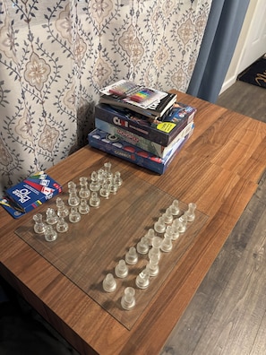 A wooden table with board games and game pieces. - Perfect 2-bedroom cottage with AC in peaceful Livingston (Livingston)