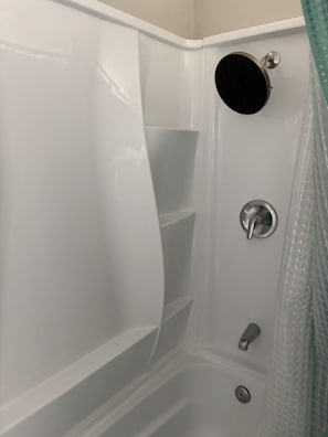 A bathroom with a bathtub, a showerhead, and a faucet. - Perfect 2-bedroom cottage with AC in peaceful Livingston (Livingston)
