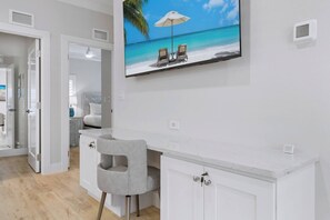 A modern hotel room with a large TV, a desk, and a chair. - The Marina Suite - Near Downtown Sarasota Bayfront (Sarasota)