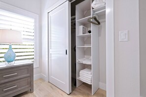 A room with a white wardrobe, a blue vase on a dresser, and a window with blinds. - The Marina Suite - Near Downtown Sarasota Bayfront (Sarasota)