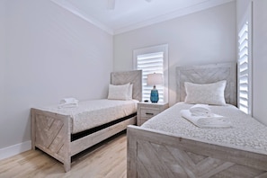 A bedroom with two wooden beds, a nightstand with a lamp, and a window with blinds. - The Marina Suite - Near Downtown Sarasota Bayfront (Sarasota)