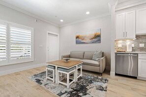 A modern living room with a sofa, a coffee table, and a painting on the wall. - The Marina Suite - Near Downtown Sarasota Bayfront (Sarasota)
