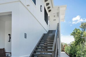 Ein modernes Gebäude mit einer Treppe, die zu einem Eingang mit der Nummer 201 führt.