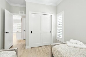 A hotel room with a bed, a wardrobe, and a bathroom visible through an open door. - Ringling Duo Suites - Downtown Sarasota, Sleeps 12 (Sarasota)