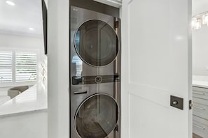 A modern bathroom with a double sink, a toilet, and a mirror. - Ringling Duo Suites - Downtown Sarasota, Sleeps 12 (Sarasota)