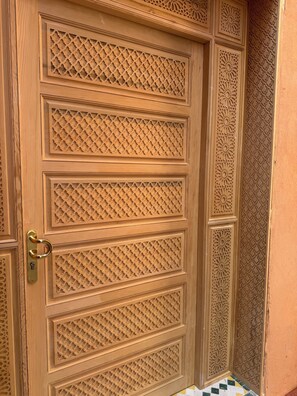 A wooden door with intricate geometric patterns and a brass handle. - Riad Dar Chafik (Marrakech)