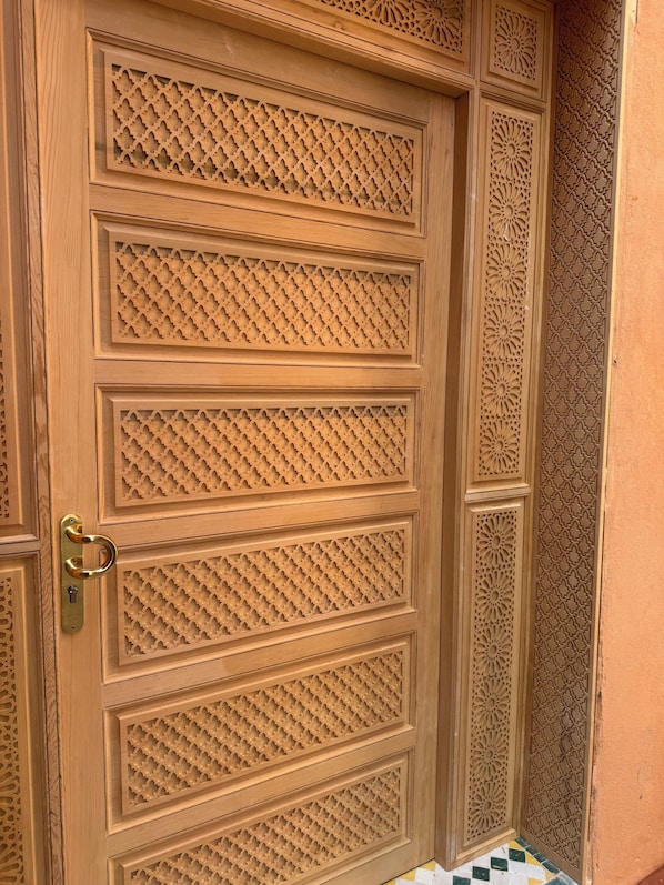 A wooden door with intricate geometric patterns and a brass handle. - Riad Dar Chafik (Marrakech)