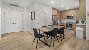 A modern kitchen with wooden cabinets, a stainless steel refrigerator, and a microwave.