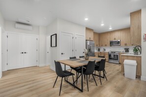 A modern kitchen with wooden cabinets, a stainless steel refrigerator, and a microwave.