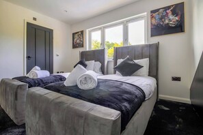 A hotel room with a large bed, two bedside tables, a window with a view, and artwork on the walls. - 4 Bedroom Luxury Home Features Hottub & Pool Table (Northwood)