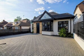 A modern two-story house with a paved driveway and a fenced backyard. - 4 Bedroom Luxury Home Features Hottub & Pool Table (Northwood)