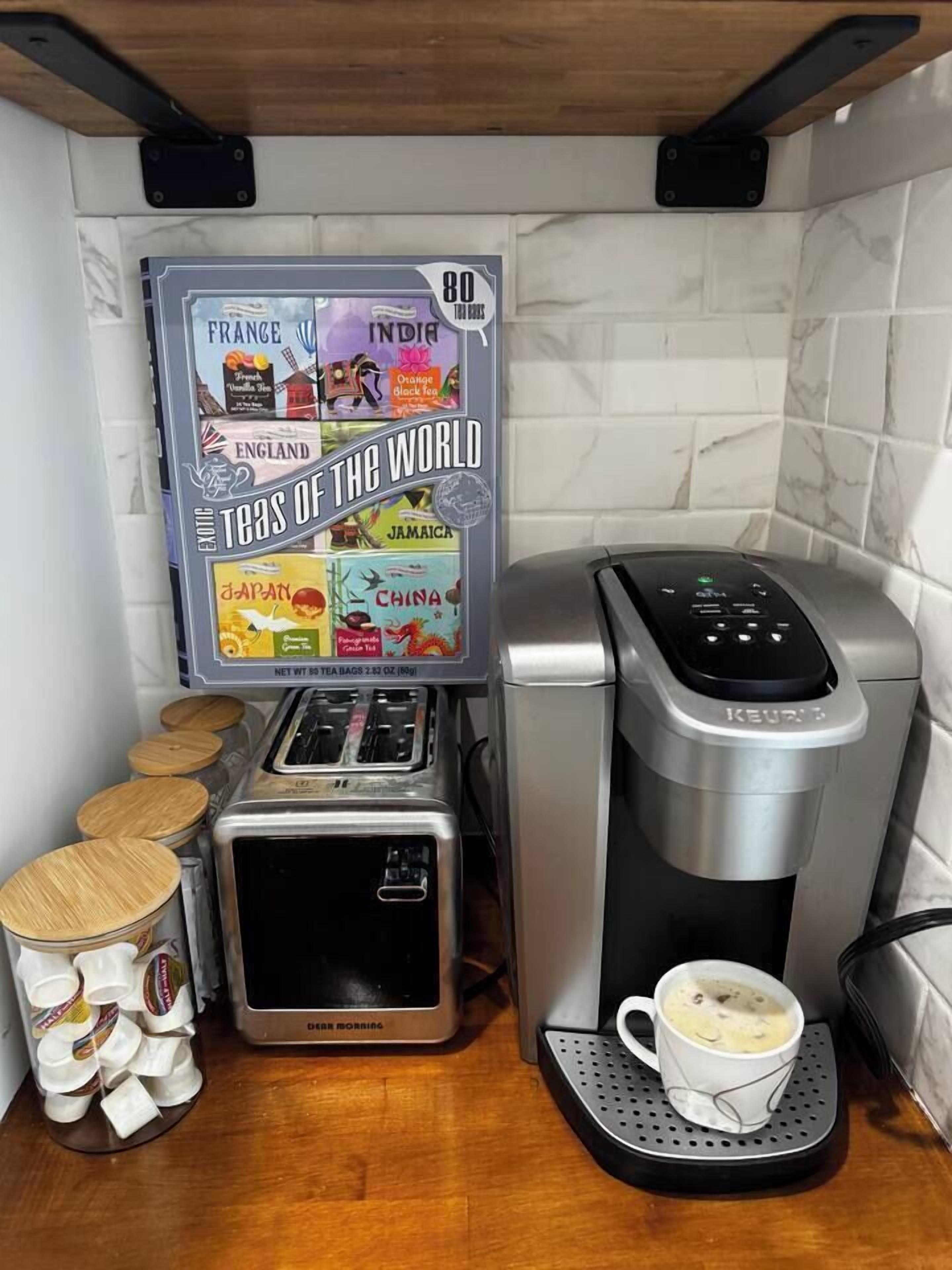 Une machine à café proposant une sélection de sachets de thé provenant de différents pays.