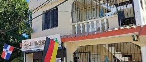 A two-story building with a sign for 'JP Inversion' and a flag.