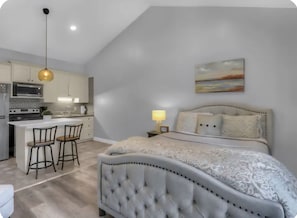 A modern bedroom with a large bed, a separate dining area with bar stools, and a kitchen with a microwave and stove. - Stylish ParkCity Boutique studio with effortless access to slopes +Free Parking (Park City)