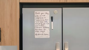Ett kylskåp i rostfritt stål med en vattendispenser och en lapp fastsatt på dörren.
