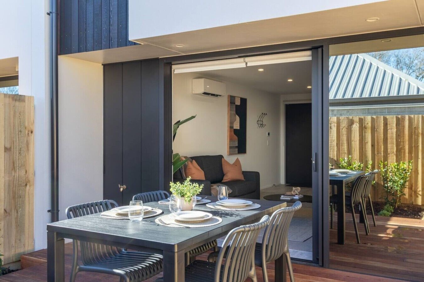 Un espace de vie à aire ouverte comprenant un coin repas, un canapé et une vue sur le jardin arrière.