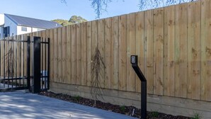 A wooden fence with a gate and a mailbox. - City Fringe 2BR 2BA Townhouse | Parking + EV (Christchurch)