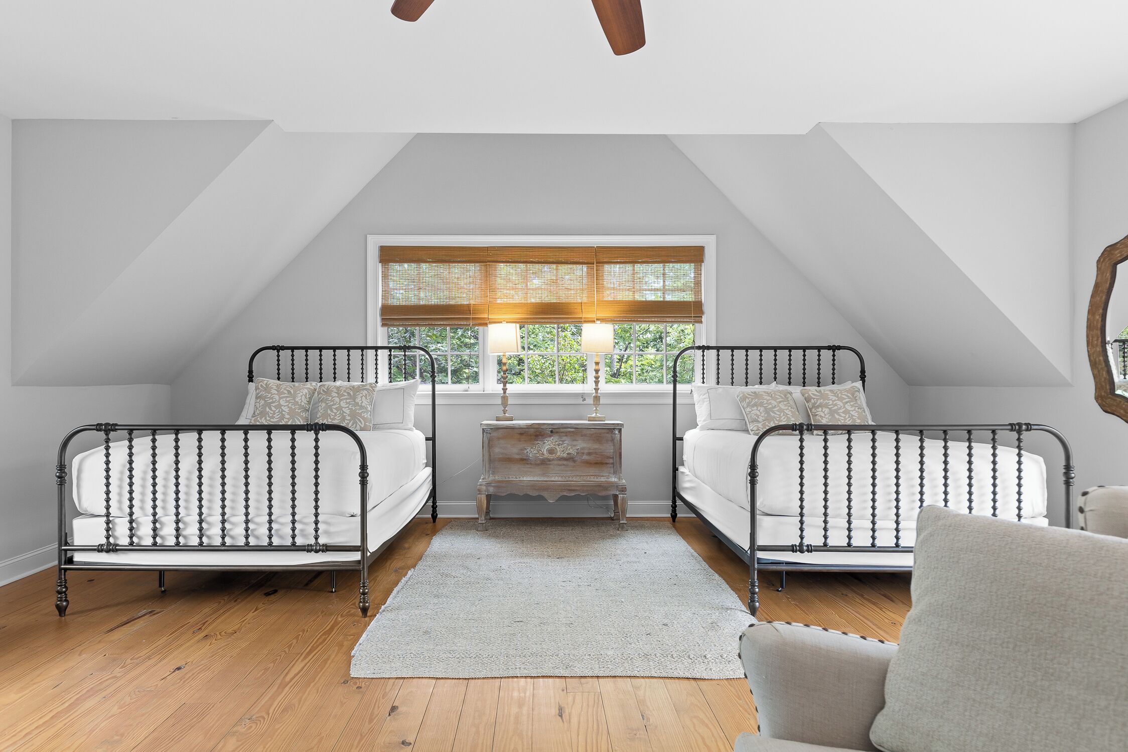 Un dormitorio con dos camas, una ventana con persianas, una mesita de noche y una silla.