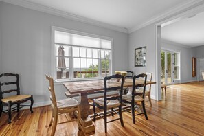 A dining area with a wooden table and chairs, large windows, and a view of the outdoors. - McLemore Resort - 856 Canyon Ridge Road - French Country Home - Walking distance to Range and Clubhouse (Rising Fawn)