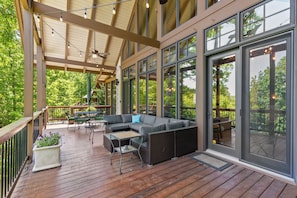 Eine Terrasse im Freien mit einer Couch, Stühlen und einem Tisch.