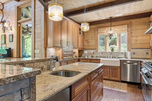 Eine geräumige Küche mit Granit-Arbeitsplatten, Edelstahlgeräten und Holzschränken.