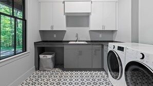 A laundry room with a washing machine, a sink, cabinets, and a trash bin. - McLemore Resort - 207 Rushing Water Trail - Golf Course View (Rising Fawn)