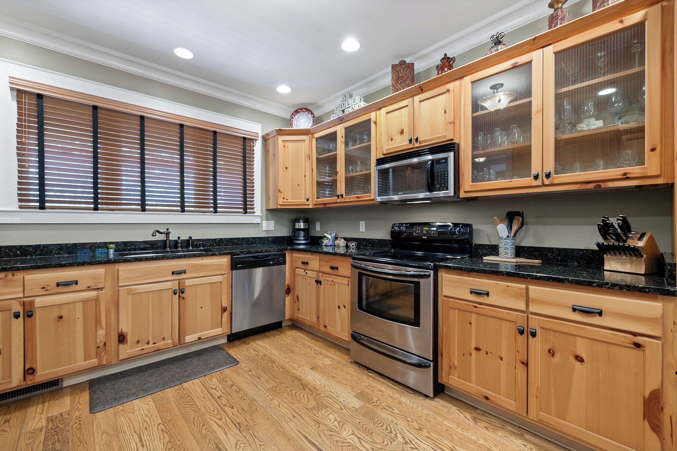 A kitchen with wooden cabinets, a stainless steel dishwasher, a microwave, and an oven.