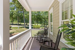 A covered porch with a view of a park and a building in the background. - McLemore Resort - 454 Rushing Water Trail - Golf Course View (Rising Fawn)