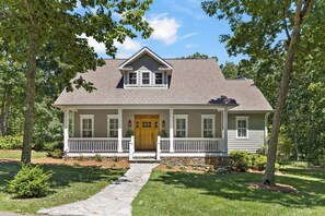 A two-story house with a front porch, a stone pathway leading to the entrance, and a well-maintained lawn. - McLemore Resort - 454 Rushing Water Trail - Golf Course View (Rising Fawn)