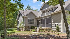 A two-story house with a stone foundation, a covered porch, and a landscaped yard. - McLemore Resort - 454 Rushing Water Trail - Golf Course View (Rising Fawn)