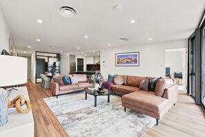 A modern living room with two sofas, a coffee table, and a rug.
