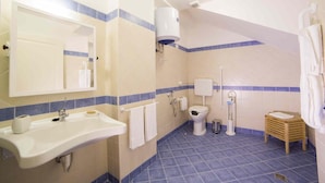 Baño con lavabo, inodoro y zona de ducha.