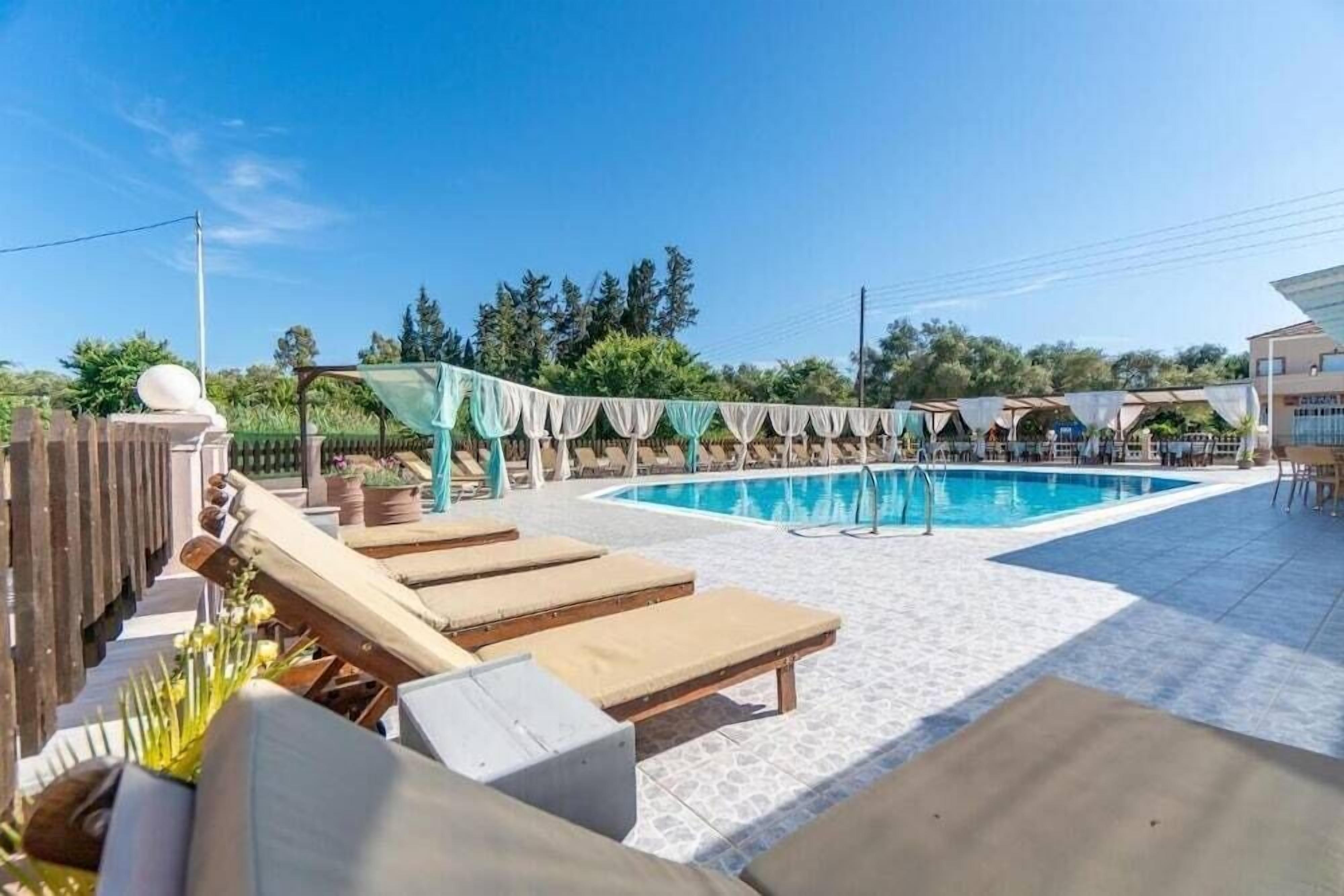 A pool area with lounge chairs and a covered seating area.