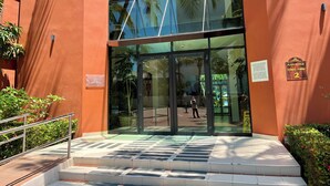 A building entrance with glass doors, a metal staircase, and a sign indicating 'Playa Royale Tower / Torre 2'. - Playa Royale Beachfront Family Condo °BBQ, Terrace & Garden Views° (Nuevo Nayarit)