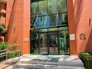 A building entrance with glass doors, a metal staircase, and a sign indicating 'Playa Royale Tower / Torre 2'. - Playa Royale Beachfront Family Condo °BBQ, Terrace & Garden Views° (Nuevo Nayarit)