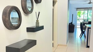 A hallway with a modern design, featuring wall-mounted shelves and mirrors. - Playa Royale Beachfront Family Condo °BBQ, Terrace & Garden Views° (Nuevo Nayarit)